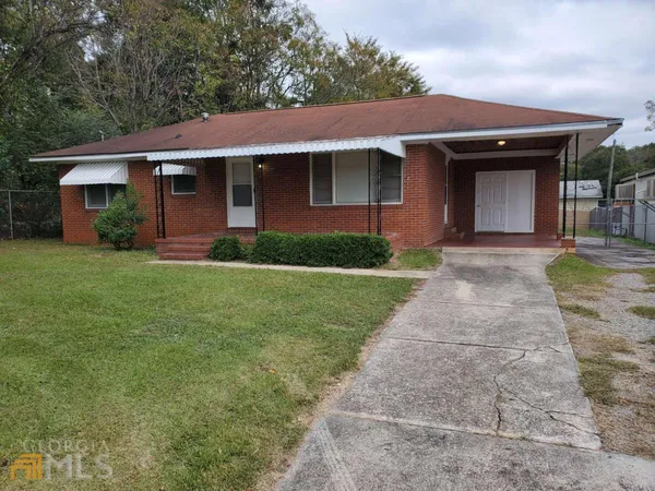 a front view of a house with a garden and yard