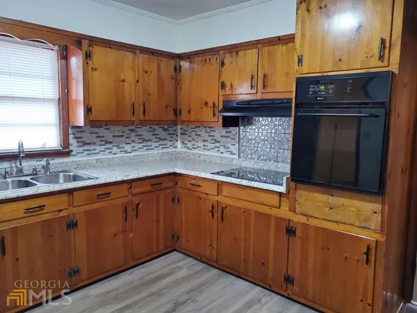a kitchen with stainless steel appliances granite countertop wooden cabinets a sink and dishwasher with wooden floor