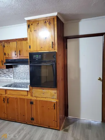 a kitchen with granite countertop cabinets stainless steel appliances and a counter space