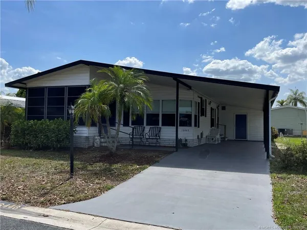a view of a house with a porch and a yard