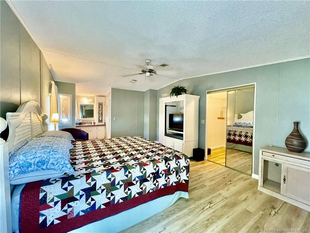 16446 Southwest Three Wood Way Indiantown, FL 34956 - Photo 15 of 32 a bedroom with a bed and dresser with mirror