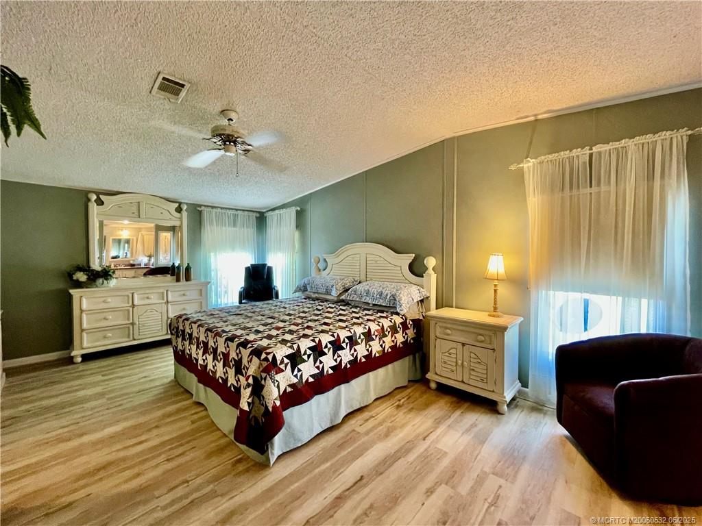 16446 Southwest Three Wood Way Indiantown, FL 34956 - Photo 17 of 32 a bedroom with a bed a couch and dresser