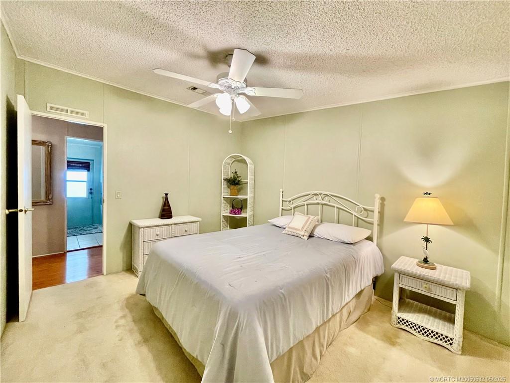 16446 Southwest Three Wood Way Indiantown, FL 34956 - Photo 22 of 32 a bedroom with a bed and a chandelier