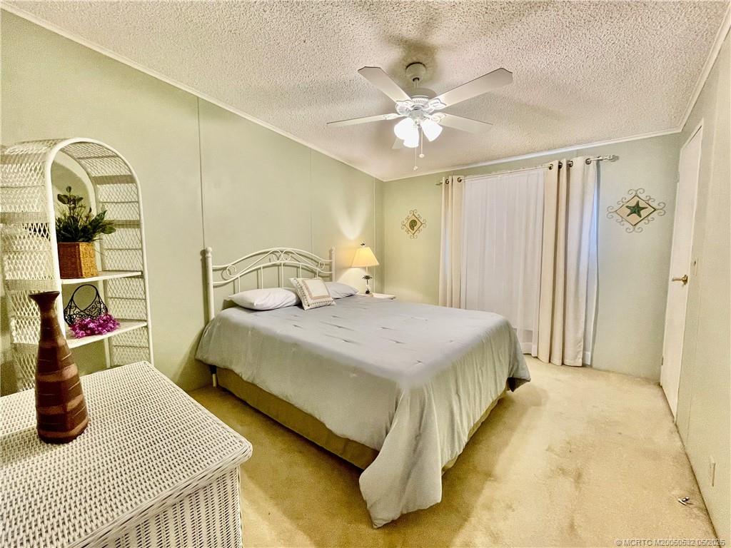 16446 Southwest Three Wood Way Indiantown, FL 34956 - Photo 23 of 32 a bedroom with a bed and dresser