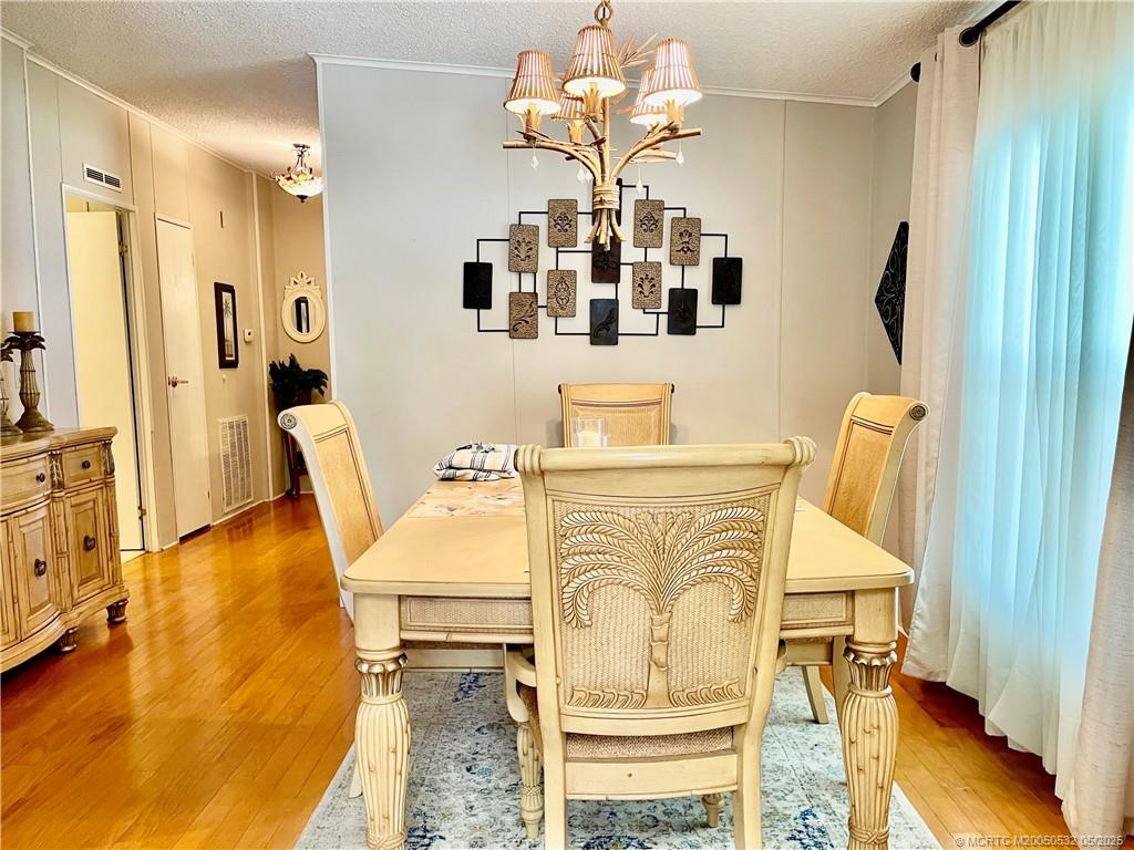 16446 Southwest Three Wood Way Indiantown, FL 34956 - Photo 30 of 32 a view of a dining room with furniture and wooden floor