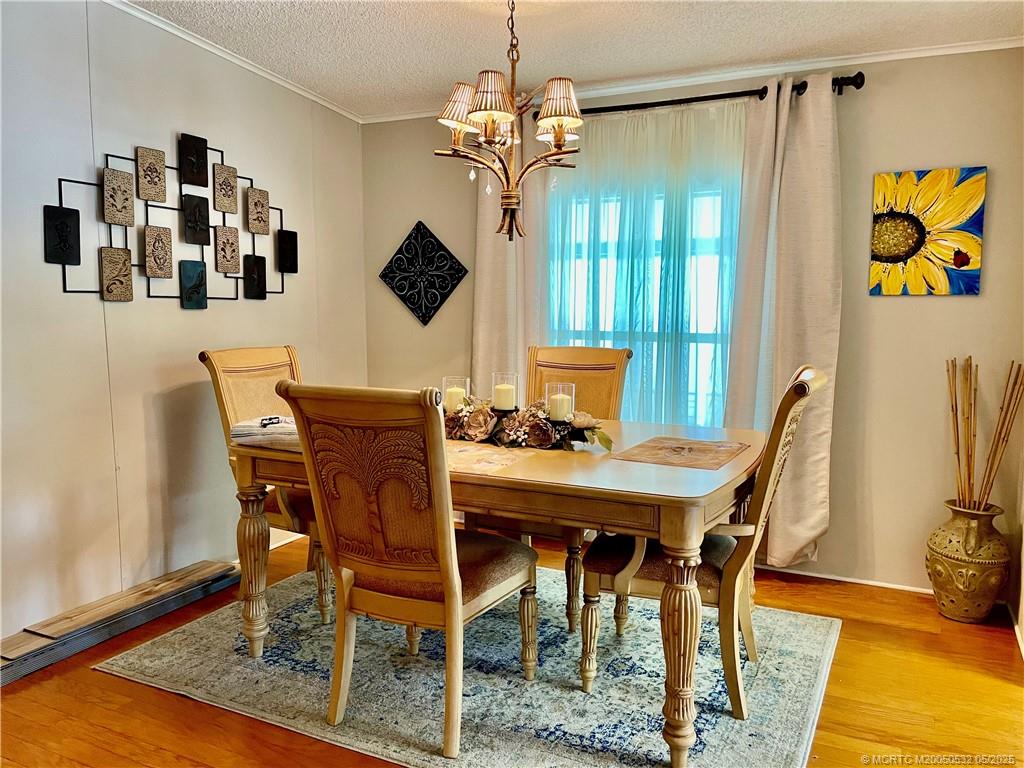 16446 Southwest Three Wood Way Indiantown, FL 34956 - Photo 31 of 32 a view of a dining room with furniture and a chandelier