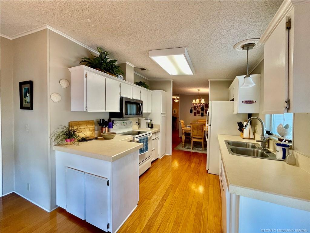 16446 Southwest Three Wood Way Indiantown, FL 34956 - Photo 7 of 32 a kitchen with stainless steel appliances a sink a stove top oven a counter space and cabinets