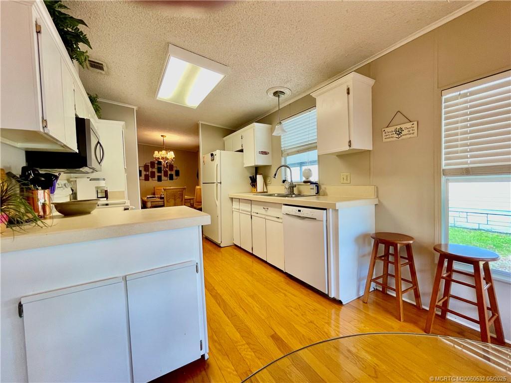16446 Southwest Three Wood Way Indiantown, FL 34956 - Photo 8 of 32 a kitchen with cabinets a sink and appliances