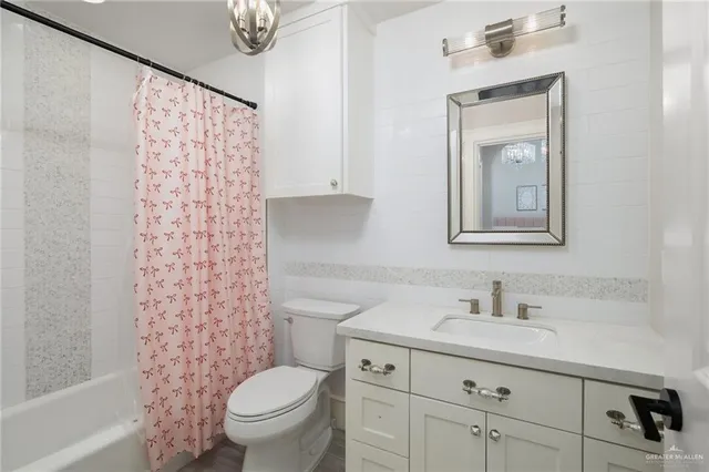 a bathroom with a sink a toilet and shower curtain