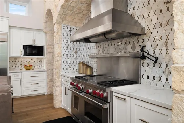 a kitchen with stainless steel appliances a stove and a microwave