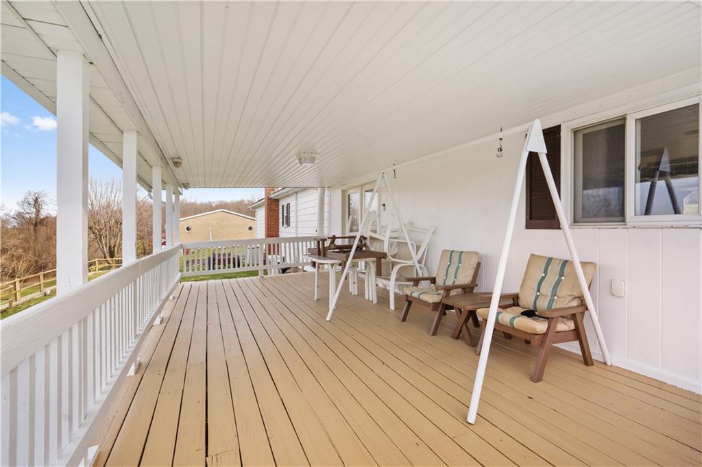 471 Pleasant View Smock Road Smock, PA 15480 - Photo 7 of 25 a view of a patio with dining table and chairs with wooden floor