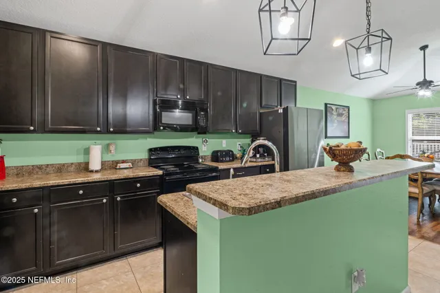 a kitchen with kitchen island granite countertop a sink a counter space appliances and cabinets