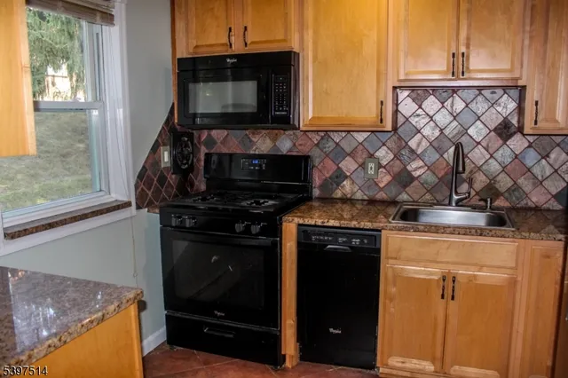 a view of an empty room with wooden floor and a bathroom