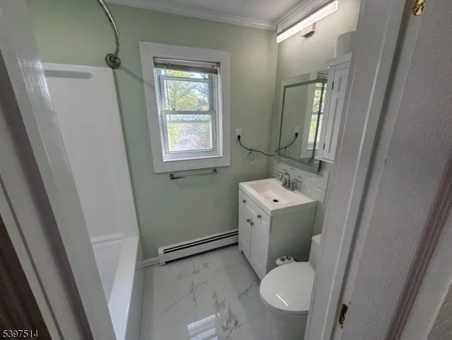 a white toilet sitting next to a bathroom sink and a mirror