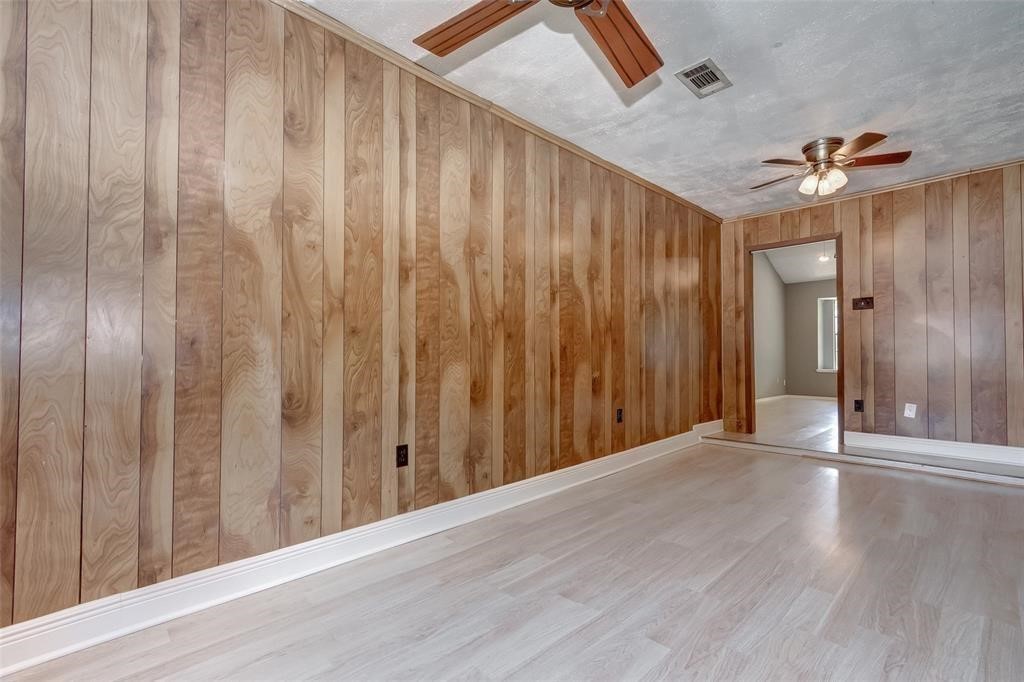 7659 Winkle Wood Lane Houston, TX 77086 - Photo 12 of 24 a view of a hallway with wooden floor and a chandelier fan