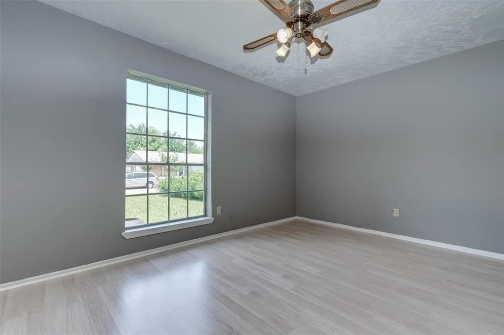 7659 Winkle Wood Lane Houston, TX 77086 - Photo 13 of 24 an empty room with windows and fan