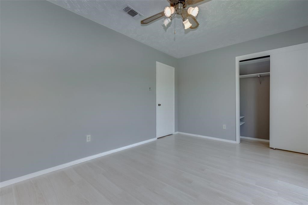 7659 Winkle Wood Lane Houston, TX 77086 - Photo 14 of 24 a view of an empty room with a chandelier fan