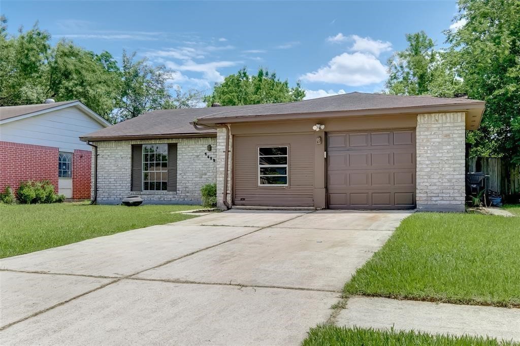 7659 Winkle Wood Lane Houston, TX 77086 - Photo 3 of 24 front view of a house with a yard and an trees