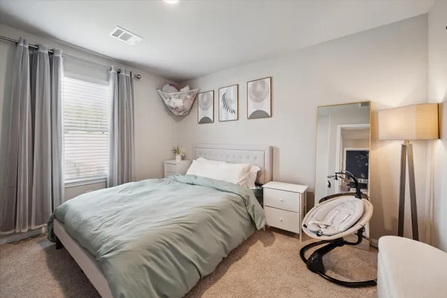 a spacious bedroom with a bed a mirror and a window