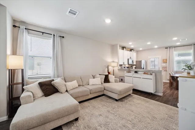 a living room with furniture and kitchen view