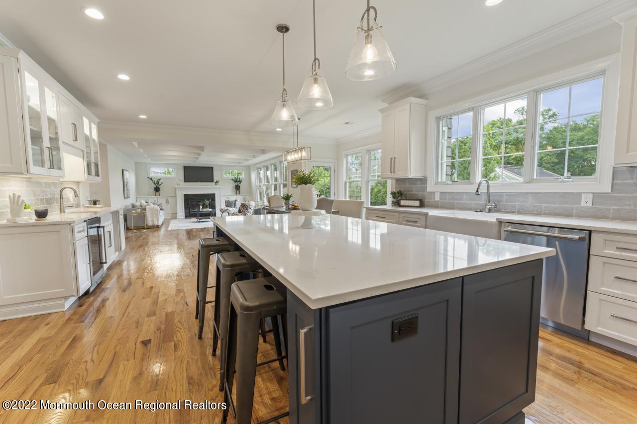 108 Horseneck Point Road Oceanport, NJ 07757 - Photo 12 of 37 a dining hall with stainless steel appliances granite countertop a kitchen island a stove a sink a dining table and chairs with wooden floors