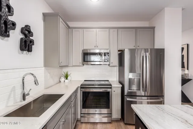 a bedroom with a large bed and a lamp on dresser