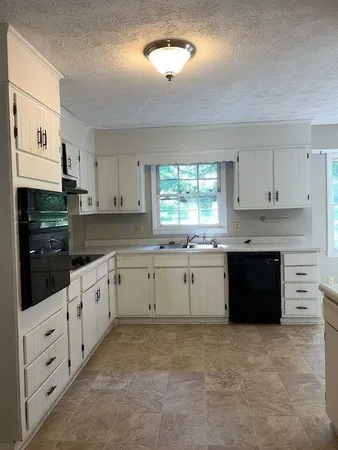 a kitchen with granite countertop a sink and cabinets