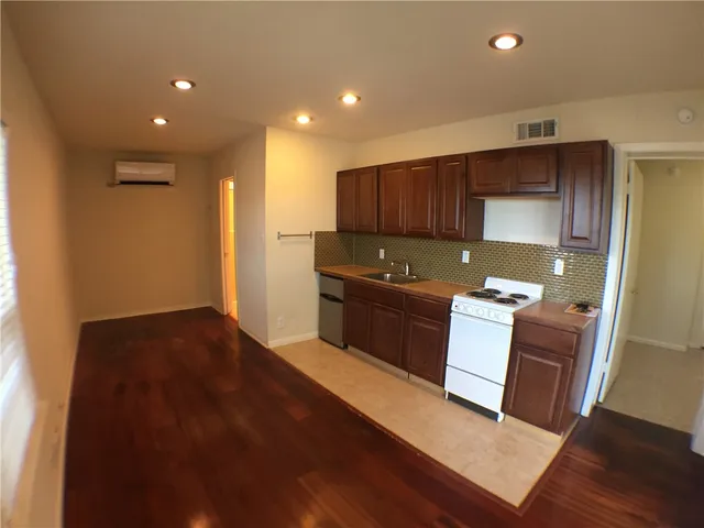 a kitchen with stainless steel appliances granite countertop a stove a sink and a refrigerator