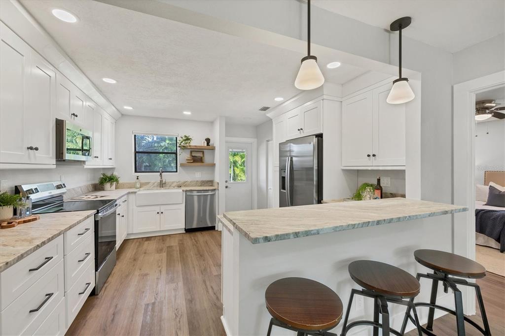 4737 Del Rio Way South Gulfport, FL 33711 - Photo 12 of 55 a large kitchen with kitchen island a large island a sink stainless steel appliances and cabinets
