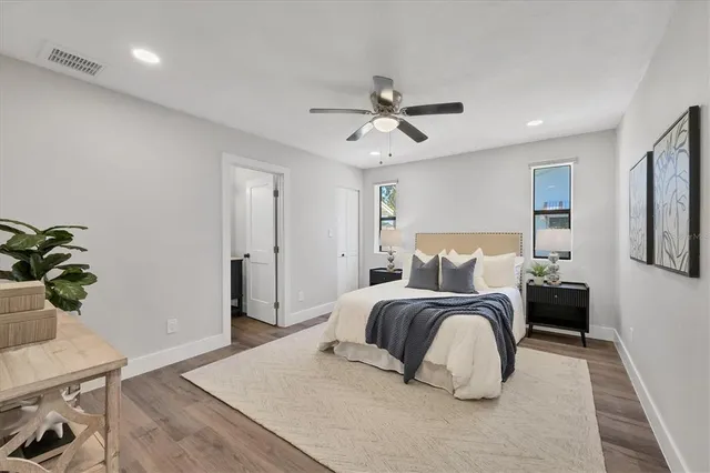 a bedroom with a bed and a potted plant on the dresser