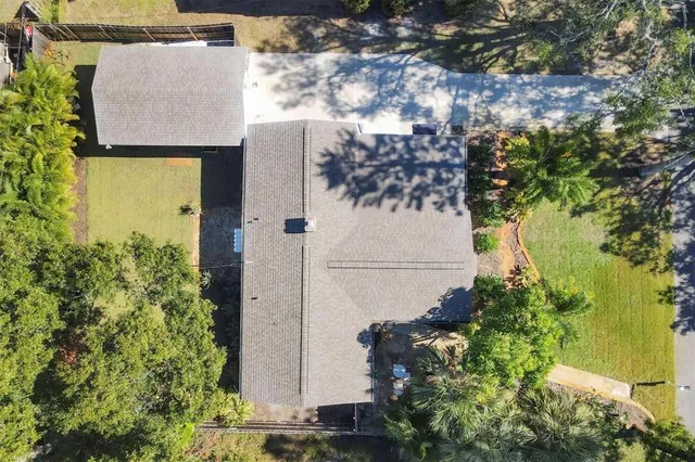 an aerial view of residential house with outdoor space and trees all around