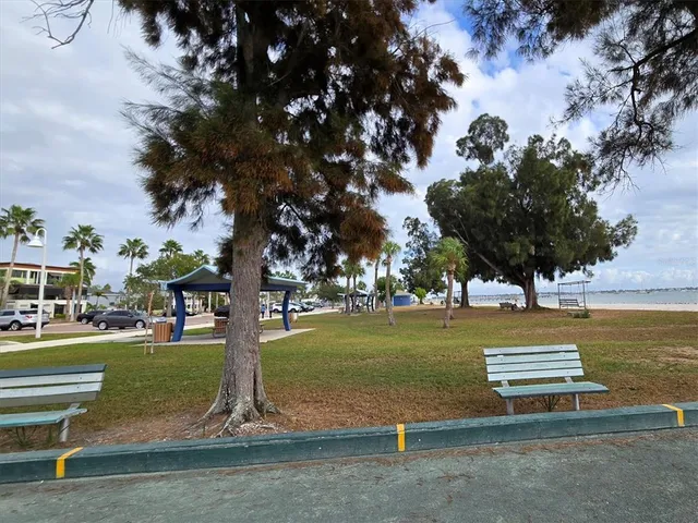 a front view of a building with lots of trees and barbeque oven