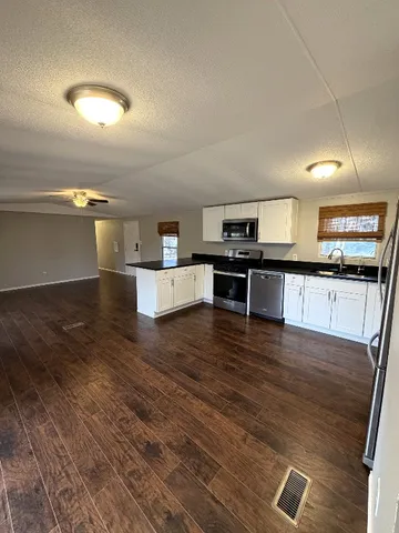 a kitchen with stainless steel appliances wooden floors and view living room