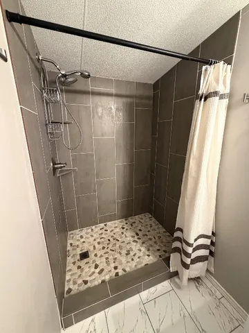 a bathroom with a shower and a wooden floor