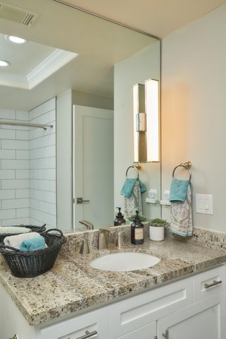 a bathroom with a granite countertop sink and a mirror