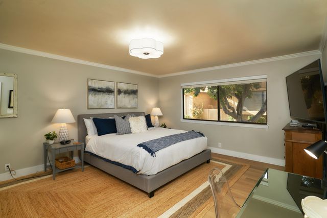 a spacious bedroom with a bed and a flat screen tv