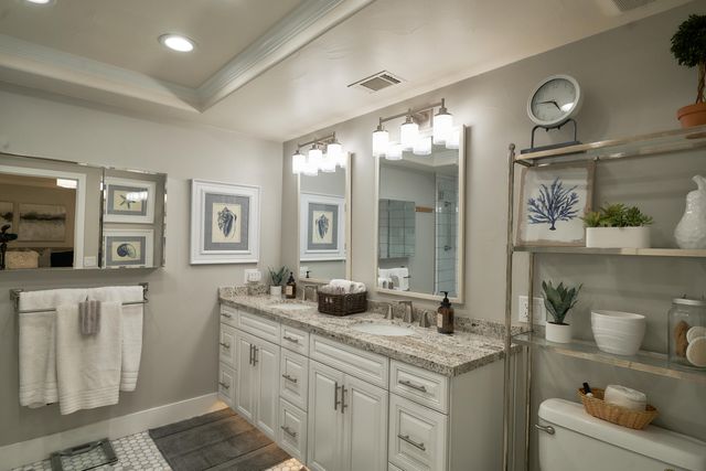 a bathroom with a granite countertop sink and a mirror