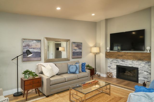 a living room with furniture a flat screen tv and a fireplace