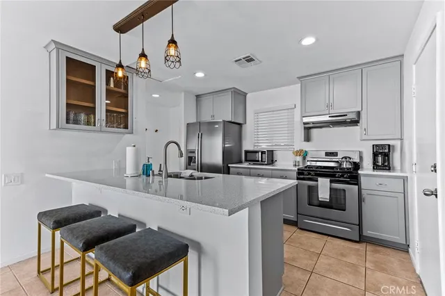a kitchen with granite countertop a stove and a white cabinets