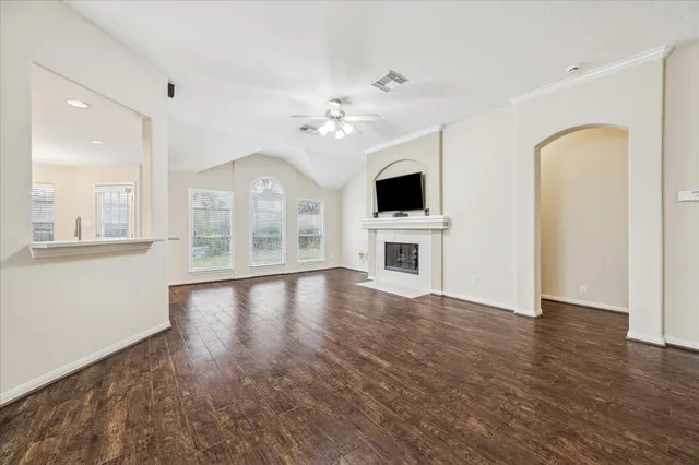 a view of an empty room with a kitchen and a window