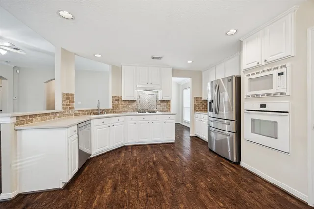 a kitchen with white cabinets and stainless steel appliances