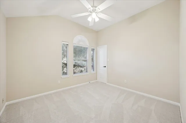 an empty room with a window and a fan