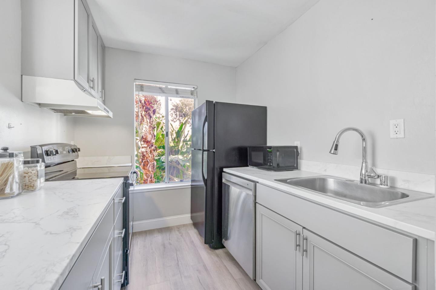 1680 Laguna Street, Unit H Concord, CA 94520 - Photo 4 of 12 a kitchen with a sink dishwasher a refrigerator and cabinets with wooden floor