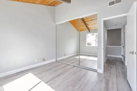 an empty room with wooden floor and door