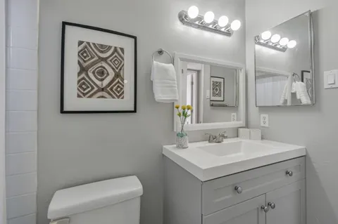 a bathroom with a toilet sink and mirror