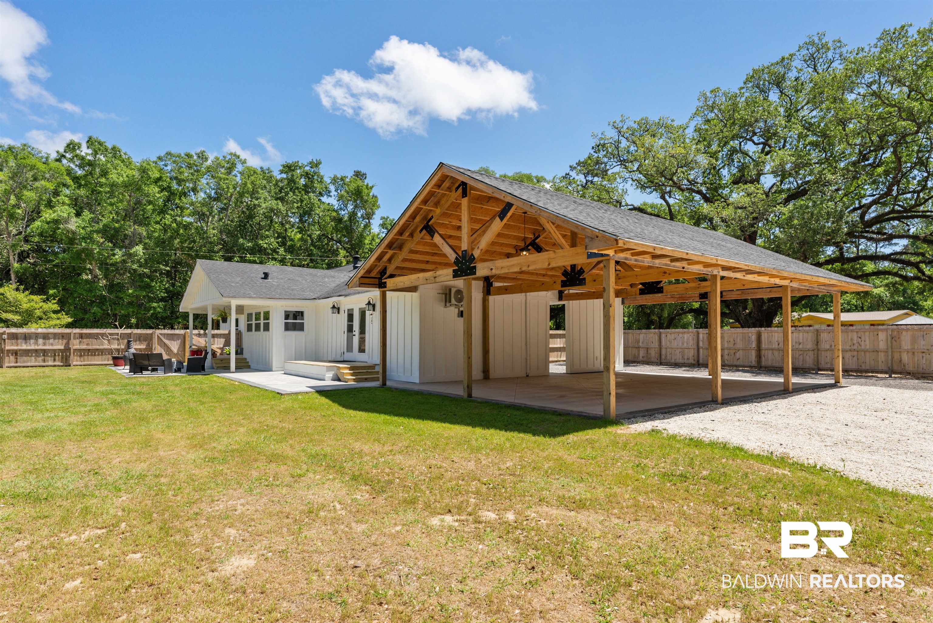 6447 Bemis Lane Bon Secour, AL 36511 - Photo 6 of 62 Rear exterior with a white board-and-batten facade and a dark shingled roof