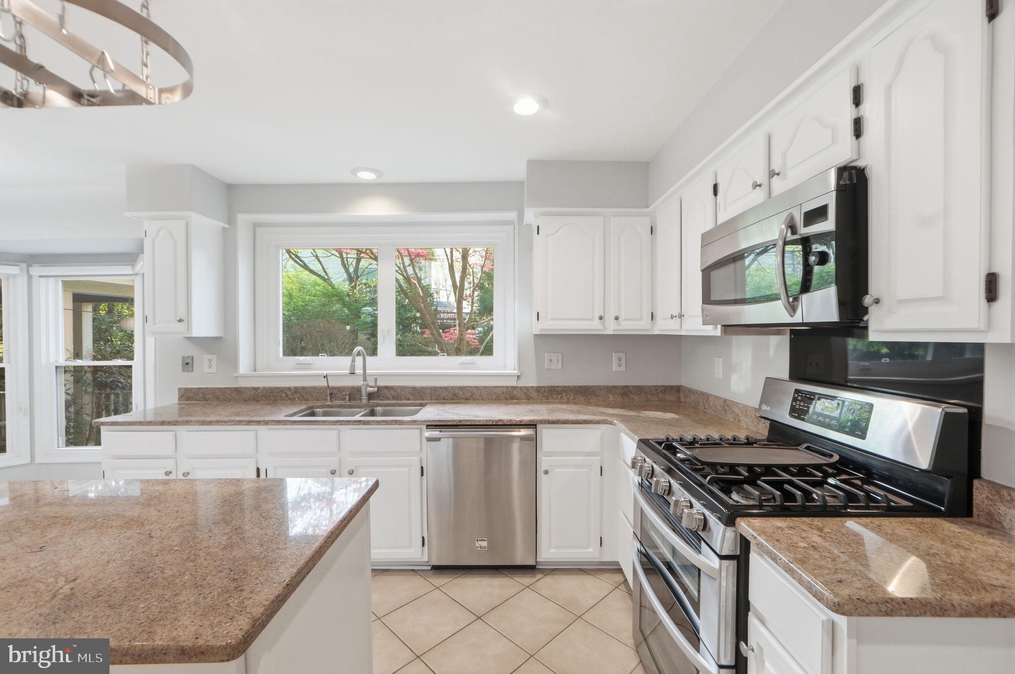 7504 Mullingar Court Springfield, VA 22153 - Photo 12 of 60 a kitchen with stainless steel appliances granite countertop a stove a sink and a microwave