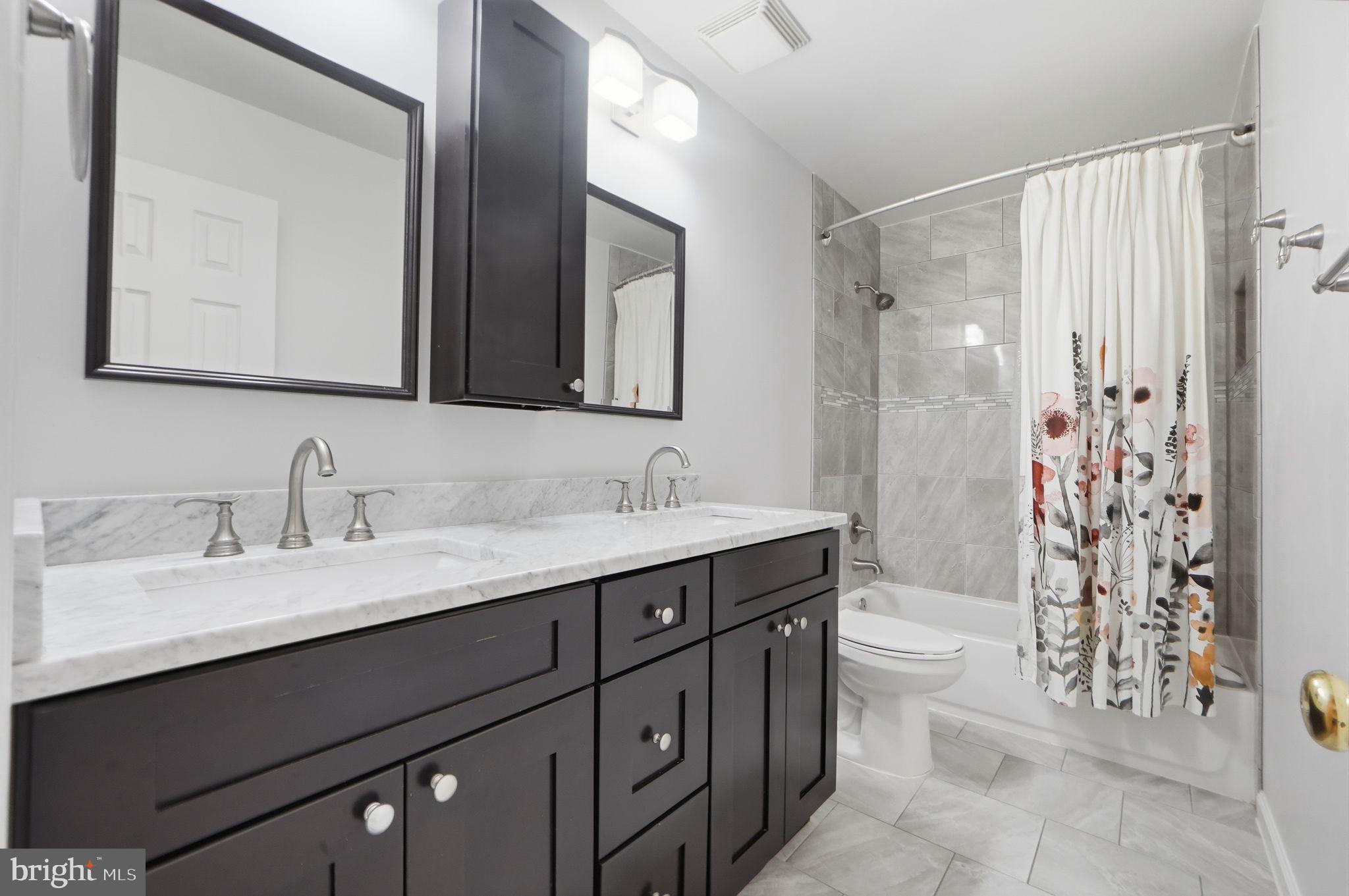 7504 Mullingar Court Springfield, VA 22153 - Photo 41 of 60 a bathroom with a double vanity sink toilet and shower