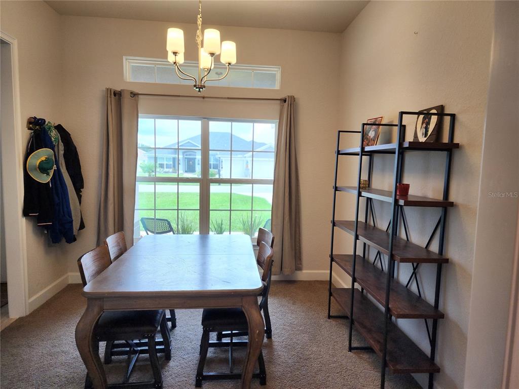 9148 Southeast 49th Avenue Road Ocala, FL 34480 - Photo 3 of 22 a view of a dining room with furniture and a chandelier