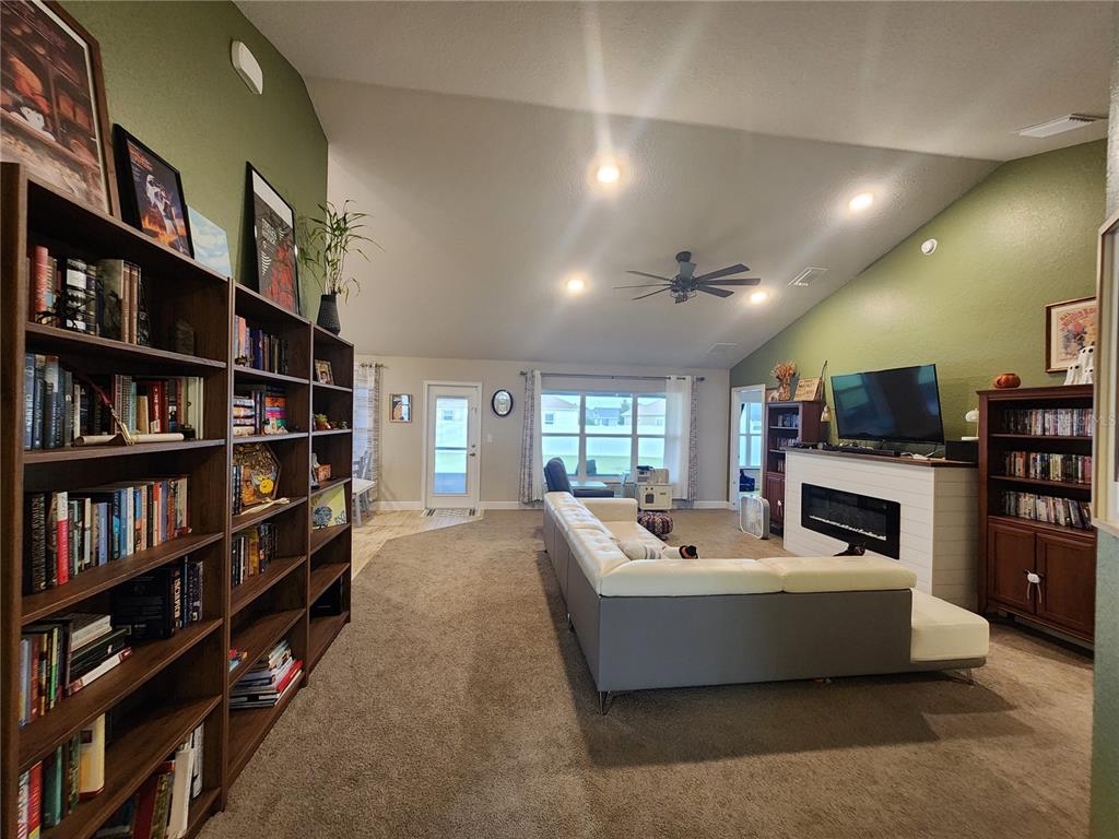 9148 Southeast 49th Avenue Road Ocala, FL 34480 - Photo 5 of 22 a living room with furniture and a book shelf